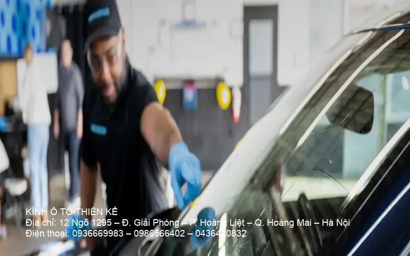 Technician inspecting a car windshield